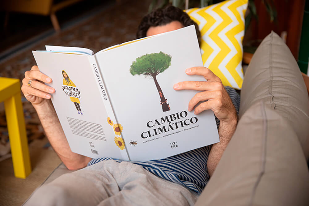hombre en el sofa leyendo libro sobre cambio climatico